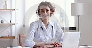 Portrait of smiling 30s female doctor in white medical coat.