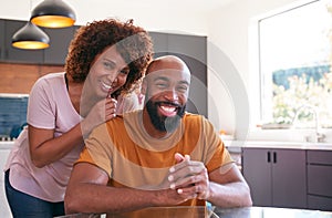 Portrait Of Smiling African American Adult Son With Mother In Kitchen At Home