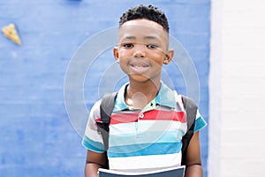 Portrait of smiling african american boy in elementary school playground, copy space