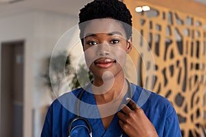 Portrait of smiling african american female doctor in hospital corridor