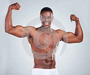 Portrait of a smiling African American fitness model posing topless in a underwear and looking muscular. Happy black