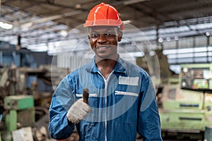 Portrait of smiling African American industrial worker man with helmet show thumbs up in factory .happy confidence black male