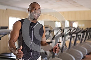 Portrait of smiling African American man in the gym. He has thumbs up in positive attitude