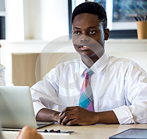 Portrait of smiling African American student sitting in cafe, black millennial man posing making picture in coffeeshop,  male