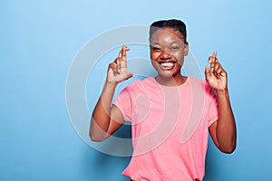 Portrait of smiling african american teenager keeping fingers crossed