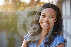 Portrait Of Smiling African American Woman In Garden At Home Against Flaring Sun