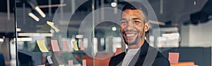 Portrait of smiling african businessman standing in office with crossing hands