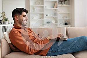 Portrait of smiling Arab man using pc at home