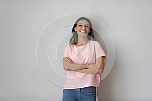 Portrait smiling Arabian woman with hands crossed on grey background