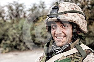 Portrait of smiling army soldier in ragged helmet