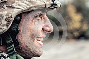 Portrait of smiling army soldier in ragged helmet