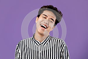 Portrait of smiling Asian guy posing laughing at studio