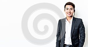 Portrait of a smiling asian man with headset working as a call center operator isolated on white background