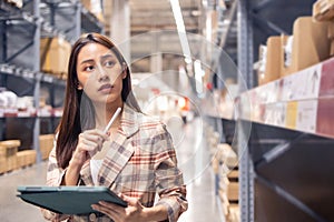 Portrait of smiling asian manager worker woman standing and order details on tablet computer for checking goods  in warehouse