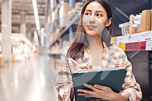 Portrait of smiling asian manager worker woman standing and order details on tablet computer for checking goods  in warehouse