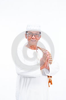 Portrait of smiling asian muslim old man wear white clothes welcoming you isolated over whit