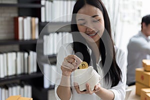 Portrait of smiling asian young woman hold piggy bank and Coin