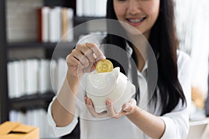 Portrait of smiling asian young woman hold piggy bank and Coin