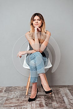 Portrait of a smiling attractive girl sitting on a chair