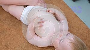 Portrait of smiling baby who is doing preventive massage in clinic by doctor.