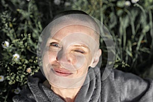 Portrait of a smiling bald woman on a background of grass