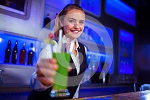 Portrait of smiling bartender serving cocktail