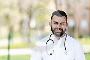 Portrait of a smiling bearded Male Caucasian Doctor in the Park, Global Pandemic