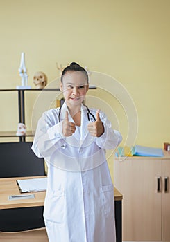 Portrait of smiling beautiful asian woman doctor showing two thumps up sign at hospital,Happy and positive attitude