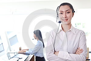 Portrait of smiling beautiful Asian woman with headphones work at call center service desk consultant, call center operator agent