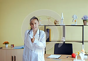 Portrait of smiling beautiful asian women doctor standing and showing thumps up sign at hospital,Happy and positive attitude