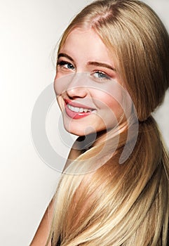 Portrait of smiling beautiful blonde young woman face.  Spa model girl with fresh clean skin isolated on a white background