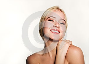 Portrait of smiling beautiful blonde young woman face.  Spa model girl with fresh clean skin isolated on a white background
