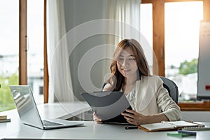 Portrait of smiling beautiful business asian woman with working in modern office desk using computer, Business people