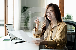 Portrait of smiling beautiful business asian woman with working in modern office desk using computer, Business people