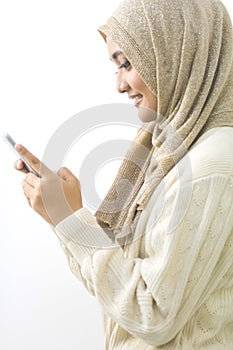 Portrait of a smiling beautiful muslim woman texting with her sm