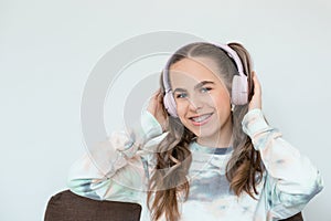 Portrait of smiling beautiful teenage girl with braces listening music in headphones, audiobook, lecture