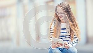 Portrait of a smiling beautiful teenage girl with dental braces. Young schoolgirl with school bag and tablet device