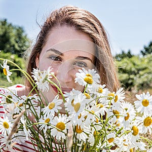 Portrait of smiling beautiful young woman with daisy flower bouquet