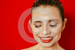 Portrait of a smiling beautiful young woman. Red background. Studio shot.