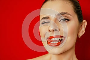 Portrait of a smiling beautiful young woman. Red background. Studio shot.