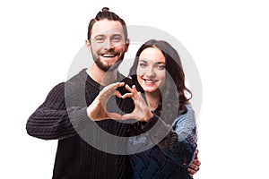 Portrait of smiling beauty girl and her handsome boyfriend making shape of heart by their hands.