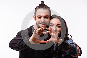 Portrait of smiling beauty girl and her handsome boyfriend making shape of heart by their hands.