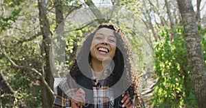 Portrait of smiling biracial woman in forest during hiking in countryside