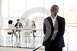 Portrait of smiling black businessman standing posing in office