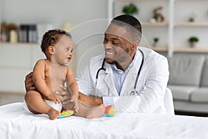Portrait Of Smiling Black Doctor Making Check Up For Infant Baby Boy