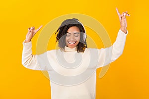 Portrait of smiling black girl listening to music and dancing