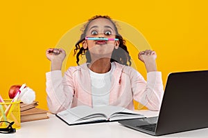 Portrait of smiling black girl sitting at desk doing homework