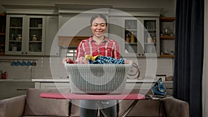 Portrait of smiling black woman holding laundry basket with washed clothes