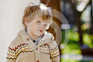 Portrait of smiling blond preschool boy, outdoors. Cute little child looking at the camera. Healthy happy kid.