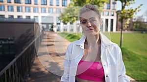 Portrait of smiling blond woman looking away turning looking at camera with blue eyes. Medium shot of Caucasian